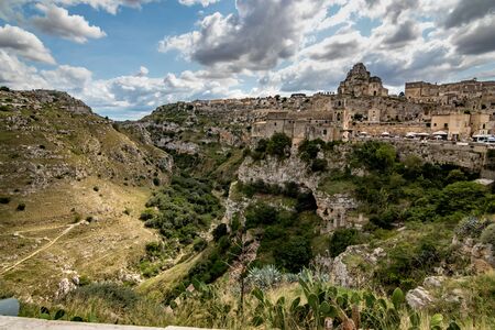 Summer day scenery street view of the amazing ancient town of the Sassi with white puffy clouds...