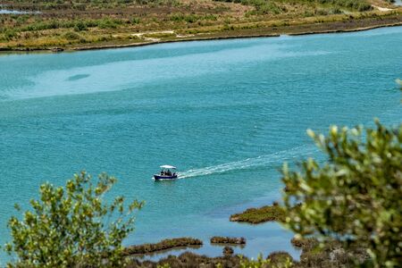 High angle sunny spring day view of salt lagoon lake in the national park of Butrint in Albania, Europe. Sailing tourist boatの写真素材