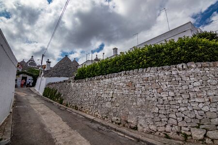 ALBEROBELLO, ITALY - AUGUST 28, 2018 - Beautiful old town of Alberobello with amazing whitewashed Trulli cone stone tiles roof houses in Apulia is visited each year by millions of touristsのeditorial素材