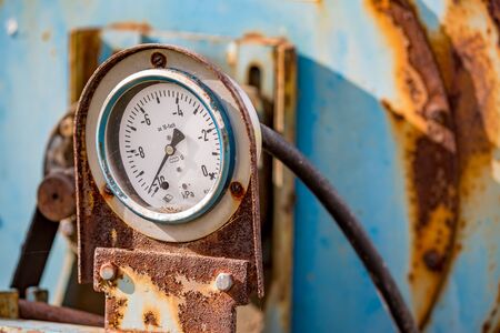 Old pressure meter, dirty rusty element details of old farm agricultural machine. Colorful close-up...