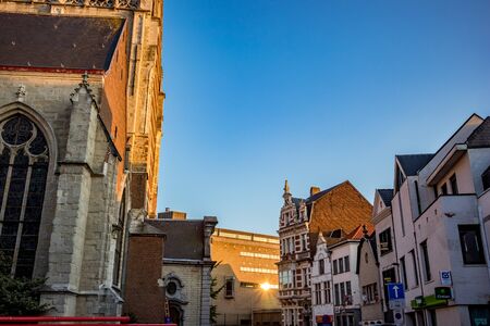 AALST, BELGIUM - AUGUST 29, 2019: Side view, corner lit by falling sunlight of Collegiate Church...