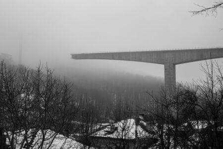 Thick winter fog and high-speed concrete bridge construction in the town of Gabrovo, Northern...