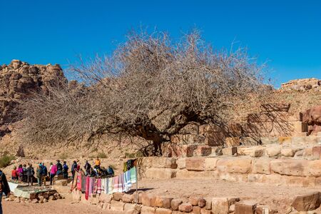 PETRA, JORDAN - JANUARY 30, 2020: Arab head scarfs are sold at the scenery Street of Facades had been created hundreds of years. Petra complex tourist attraction, Hashemite Kingdom of Jordan. Touristsのeditorial素材