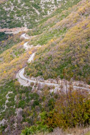 Curvy mountain empty road, Xanthi region, Northern Greece. High angle view, late autumn hazy day,...