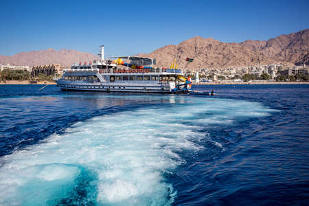 Aqaba, Jordan - February 2, 2020: Tourists enjoy views of Red Sea with glass boat tours. Cloudless...