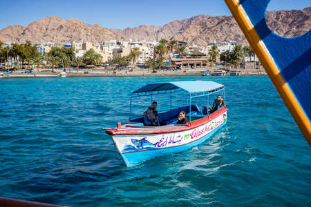 Aqaba, Jordan - February 2, 2020: Tourists enjoy views of Red Sea with glass boat tours. Cloudless clear sky winter day. Enjoying the underwater life becomes more and more popular latelyのeditorial素材
