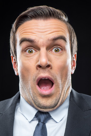 Close-up portrait of young scared businessman looking at cameraの写真素材
