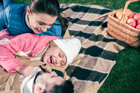 Close-up portrait of happy family having fun in park at sunny autumn day