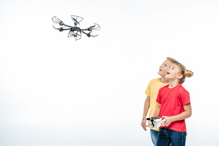 Happy kids playing with flying hexacopter drone isolated on whiteの写真素材