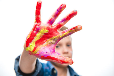 Excited schoolboy artist with painted faceの写真素材