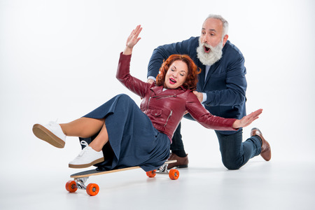 Mature couple with skateboardの写真素材