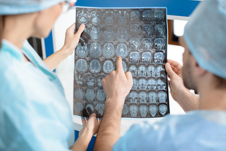 surgeons in medical uniforms examining x-ray image
