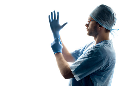 surgeon in medical uniform wearing gloves on whiteの写真素材