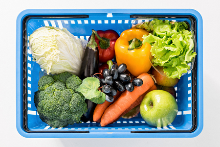 fresh ripe vegetables in shopping basket on whiteの写真素材