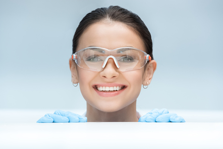 smiling scientist looking to camera behind table in labの写真素材