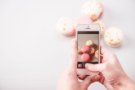 Hands photographing macaronsの写真素材