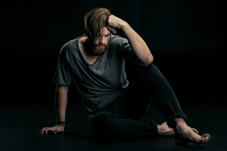 stylish handsome man sitting on floorの写真素材
