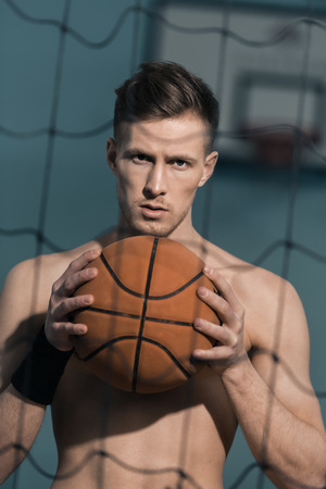 confident sporty man holding basketball ballの写真素材