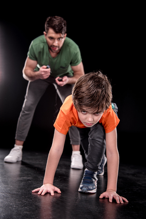 man controlling time while boy training and looking to cameraの写真素材