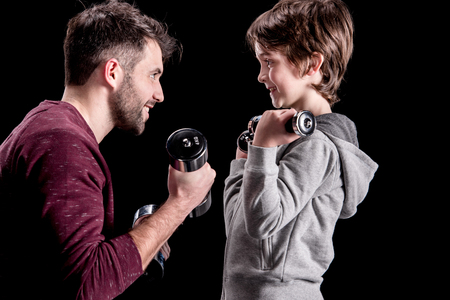 father and son training with dumbbells and looking at each otherの写真素材