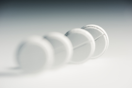 round white medical tablets in row, medicine and healthcare conceptの写真素材
