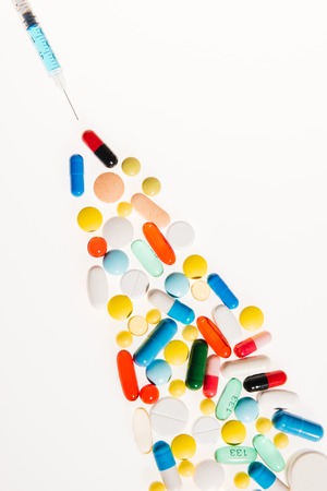 Close-up view of colorful pills and syringe on whiteの写真素材
