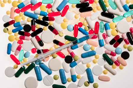 Close-up view of colorful medical pills and syringeの写真素材