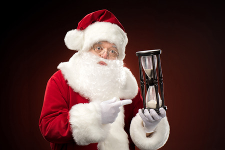Santa Claus pointing on hourglassの写真素材