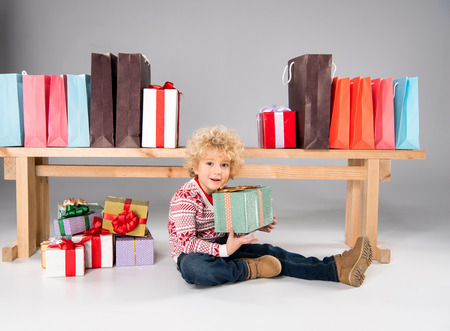 Kid with gift boxes and shopping bagsの写真素材