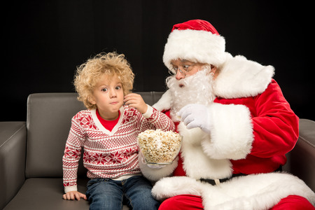 Santa Claus eating popcorn with kidの写真素材