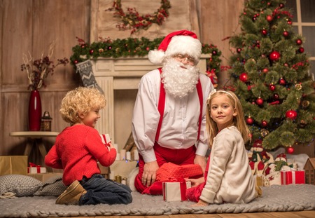 Santa Claus and children with Christmas giftsの写真素材