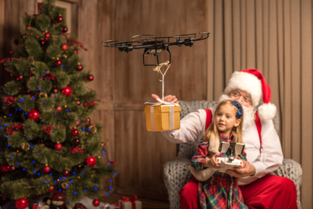 Santa with kid using hexacopter droneの写真素材