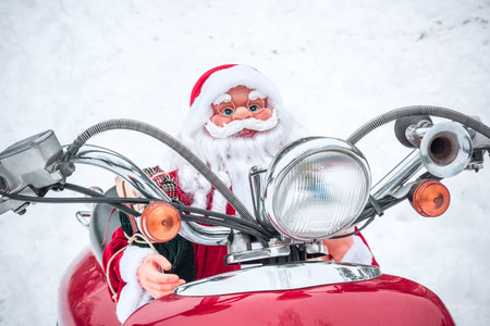 Closeup view of Santa Claus toy riding on red scooterの写真素材