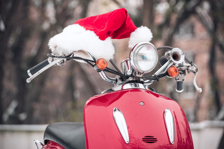 Closeup view of Santa hat lying on red scooterの写真素材