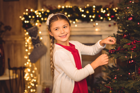 Girl decorating christmas treeの写真素材