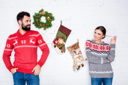 Flirting couple leaning on white wall