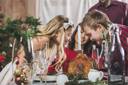 Happy siblings at holiday tableの写真素材