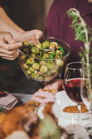 Woman putting brussel sprouts on plateの写真素材