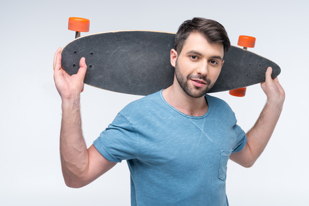 portrait of man holding skateboard in handsの写真素材