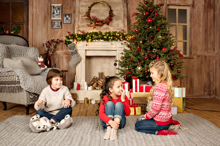 kids sitting on carpet with Christmas giftsの写真素材