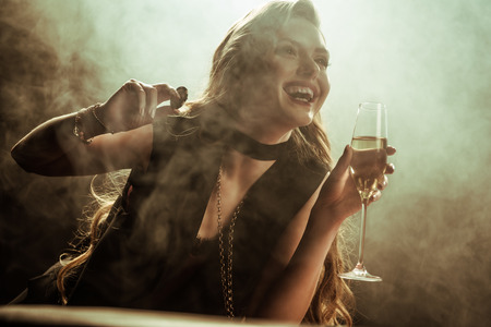laughing woman with drink and poker chip in hands