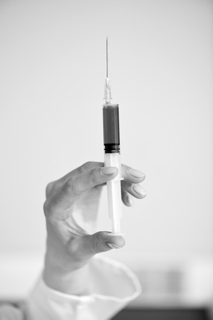 Close-up partial view of doctor holding syringeの写真素材