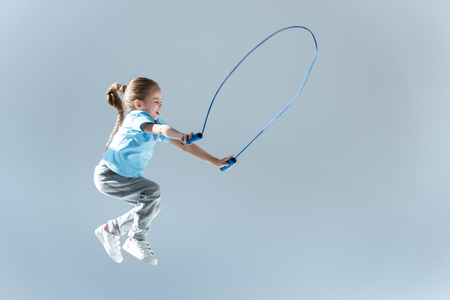 side view of happy girl humping exercising with skipping ropeの写真素材
