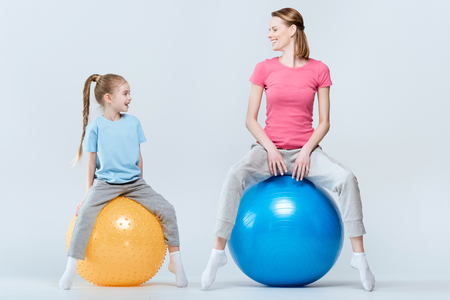 mother and daughter exercising with fitness ballsの写真素材