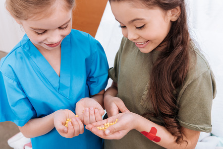 girls nurse and patient holding pills in handsの写真素材