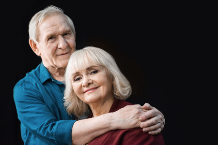 portrait of senior man hugging smiling wifeの写真素材