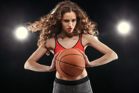 young sporty woman in sportswear posing with basketball ballの写真素材