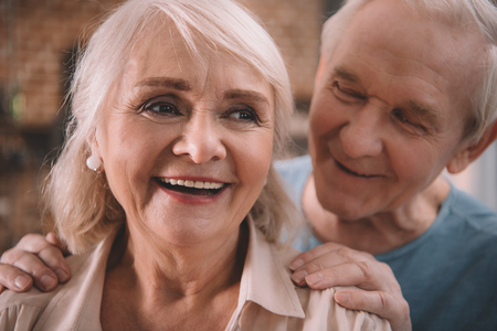 smiling senior couple standing together indoorsの写真素材