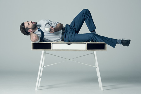 businessman lying on tableの写真素材