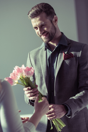 Man presenting flowers to womanの写真素材